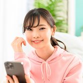 ルームウェアを着てスマホを見る女性