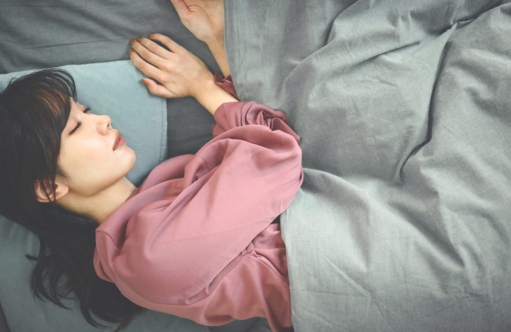 ベッドで横たわる女性